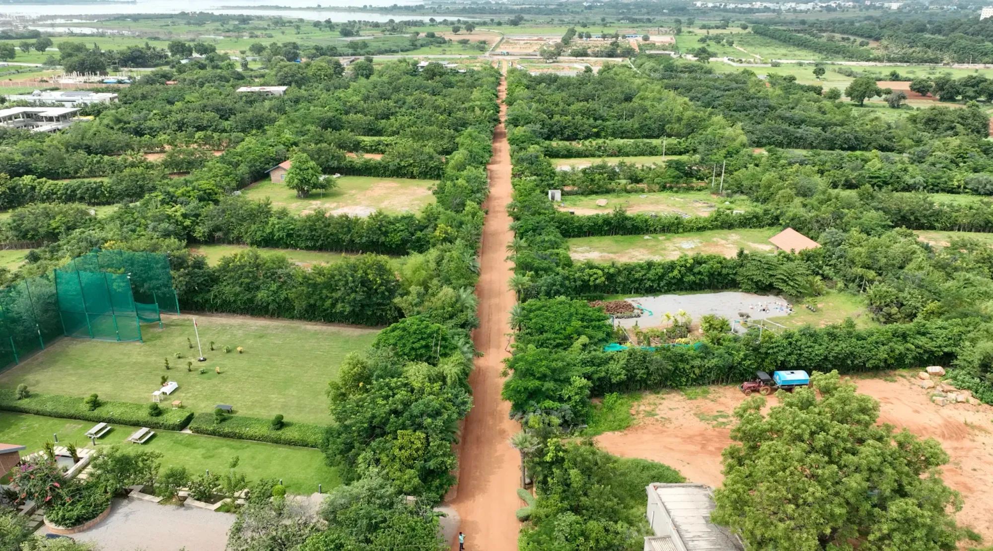 Aerial view of a green landscape and planted trees at Woods Shamshabad