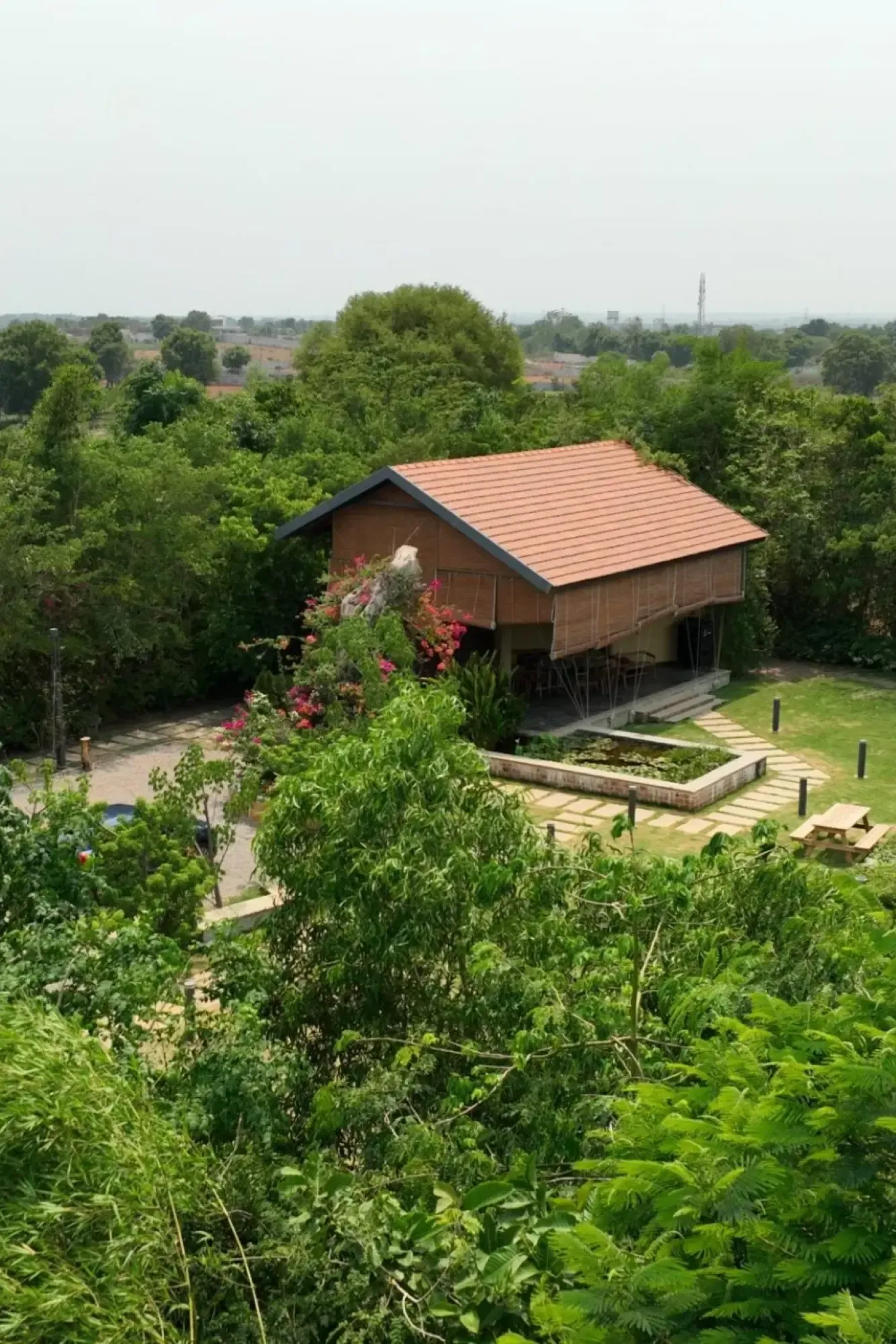 Timber-roofed house surrounded by trees at Woods Shamshabad
