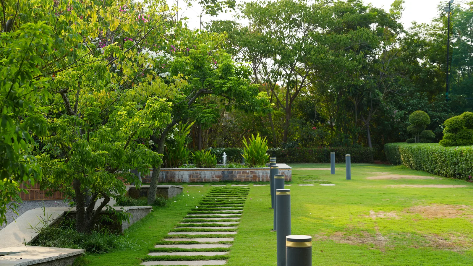 Lawn with stepping stones, lamp posts and trees at Woods Shamshabad